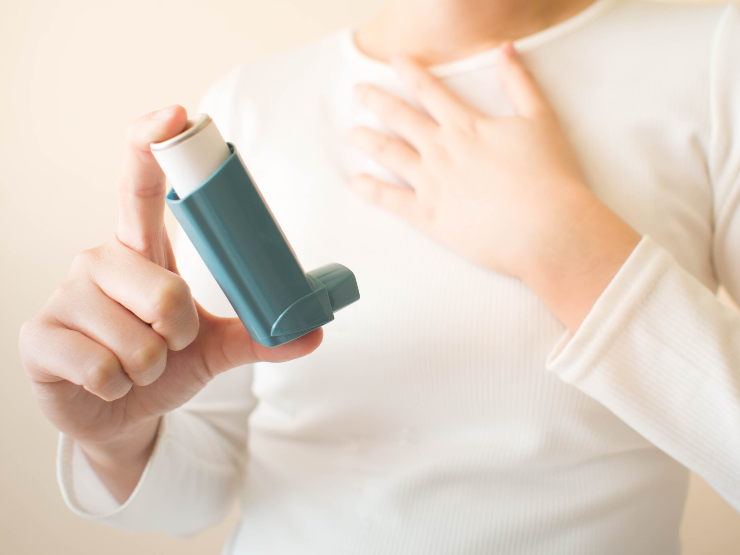 Person holding asthma inhaler to relieve asthma attack