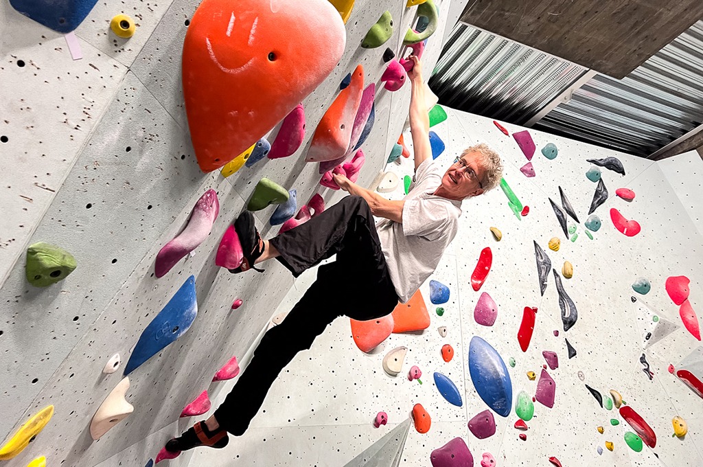 Erik Fransén climbing on a wall full of colorful climbing grips