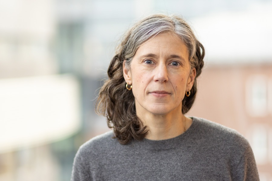 Portrait of Caroline Gallant, with blurry buildings in the background